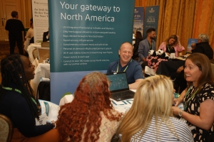 man meeting three trade show attendees sitting at the Aer Lingus booth at the Irish Travel Trade Show Dublin