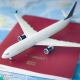 A toy plane sitting on top of a red passport on a table covered by a map.