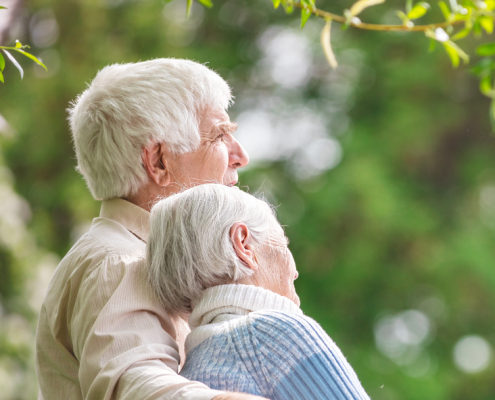 An older man with his arm around his wife