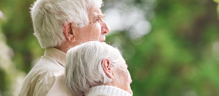 An older man with his arm around his wife