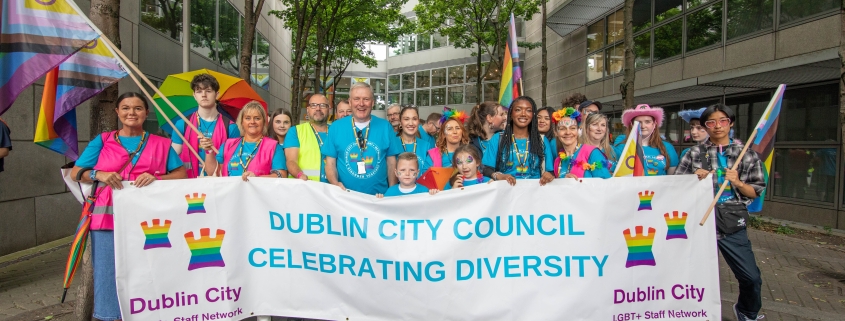 A group of people holding a large sign.
