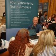 A group of people gathering at a table, laughing and talking.