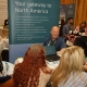 A group of people gathering at a table, laughing and talking.